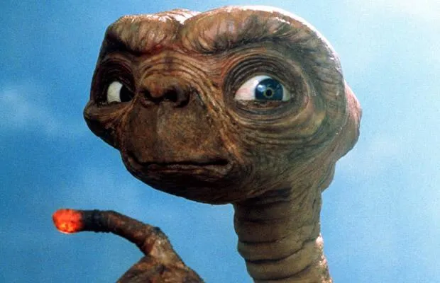 E.T., a small wrinkled alien with large eyes, against a bright sky