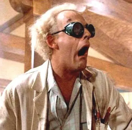 Doc Brown with wild white hair, looking shocked