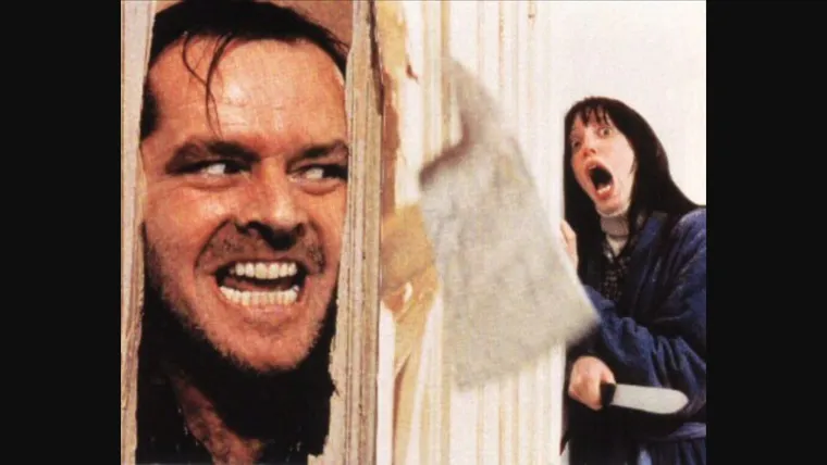 Jack Nicholson with a manic grin pushing his face through a broken door