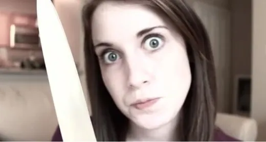 A young woman with wide eyes and a fixed smile, staring intensely into the camera