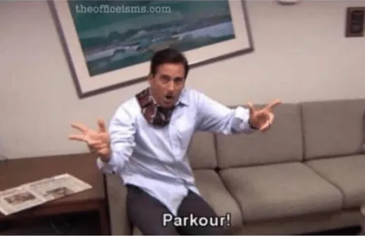 A man in an office jumping off furniture, shouting
