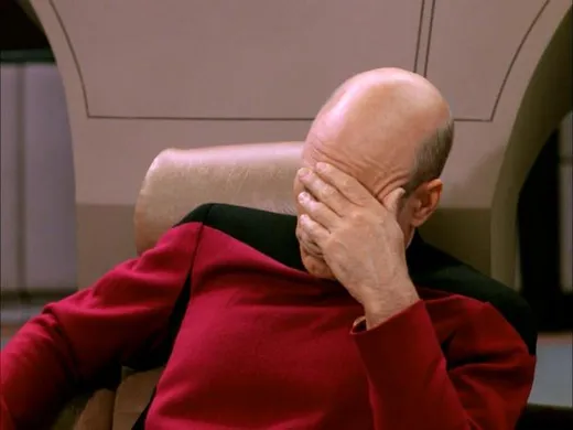 Captain Picard in his red uniform, sitting with his face in his hand