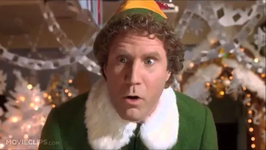 Buddy the Elf in his green costume, pointing and shouting angrily