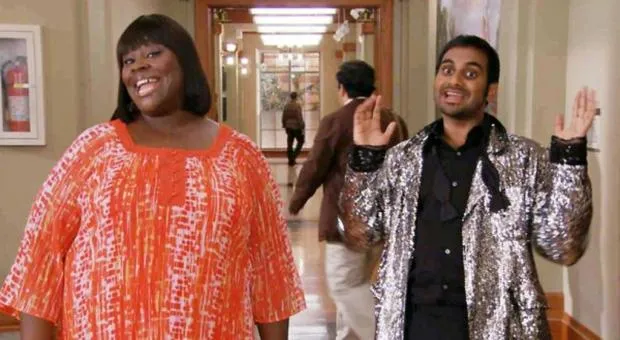 Tom Haverford and Donna Meagle walking through a mall with shopping bags, posing